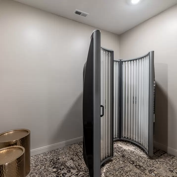 Fully furnished, modern student apartment living room featuring coffee table, mounted TV, and couch